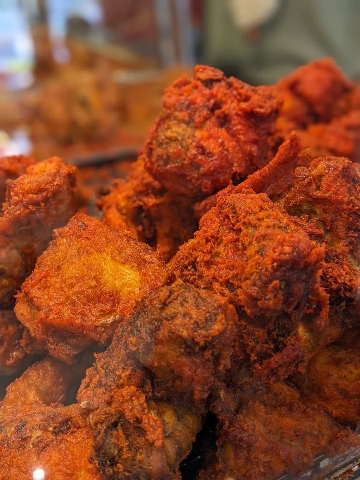 Golden fried chicken pieces stacked fresh from the fryer